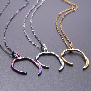 Close-up of irregular C-shaped pendants in iridescent, silver, and matte gold finishes