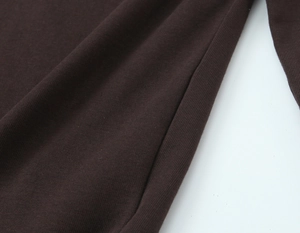 Vue macro du tissu en maille marron foncé avec texture côtelée et coutures détaillées