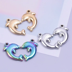 Macro detail of dolphin pendants in gold, silver and rainbow stainless steel finishes