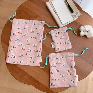 Three-piece set of pink cotton drawstring bags with duck prints for organized storage