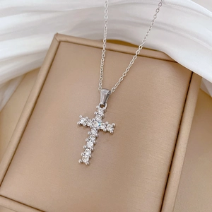 Detail of silver titanium steel cross pendant with cubic zirconia in a jewelry box