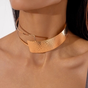 Close-up of golden hammered metal choker necklace with unique crumpled texture on model
