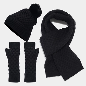 Detailed view of black knitted set featuring honeycomb texture hat, scarf, and mittens