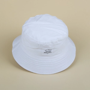 Detailed view of white canvas bucket hat with stitched brim and vintage textile label