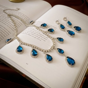 Vintage luxury jewelry set with blue teardrop crystals and silver-plated rhinestone accents