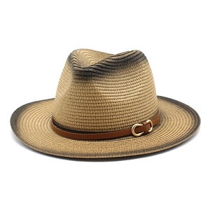 Detail of gradient woven straw fedora with brown leather band and gold horseshoe buckle