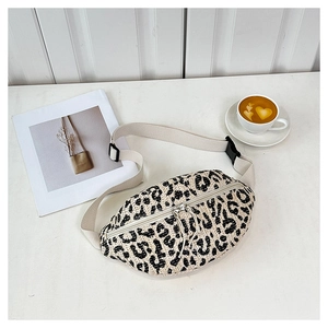 Detail view of leopard print woven fanny pack with tassel zipper and adjustable strap