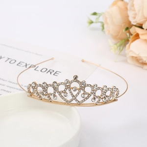 Detail of elegant gold bridal crown with crystals placed on white ceramic plate