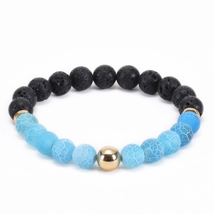 Detailed macro view of black lava stone and blue cracked agate beads with gold accents