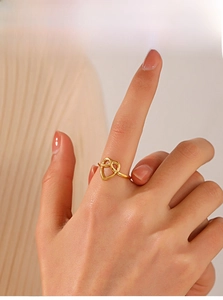 Dettaglio anello a cuore placcato oro 18K con design a torsione sul dito della modella