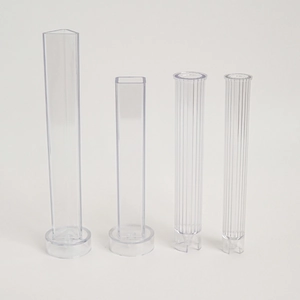 Detailed set of four clear plastic candle molds in triangle, square, and ribbed shapes