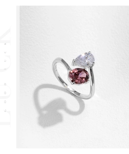 Macro shot of S925 sterling silver ring with pear-cut zircon and pink oval gemstone