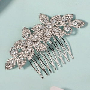 Detail of silver wedding hair comb featuring sparkling zircon flower design on blue surface