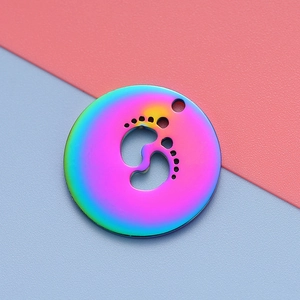 Rainbow plated stainless steel round charm featuring a laser-cut baby footprint design