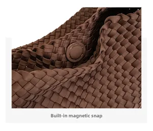 Macro detail of dark brown woven bag with a built-in magnetic snap fastener closure