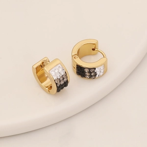 Boucles d'oreilles dorées en forme de C avec strass dégradés sur fond minimaliste