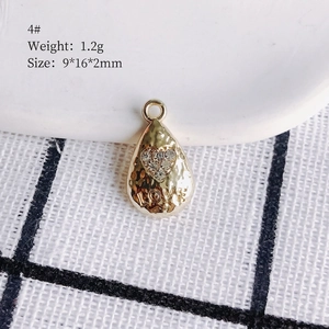 Detail of 9x16mm gold teardrop pendant with LOVE engraving and tiny heart zircon