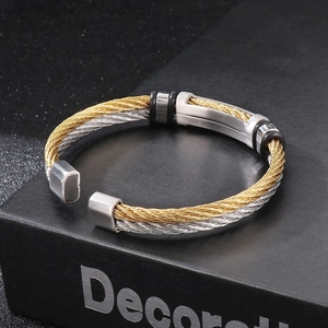 Detail of two-tone braided stainless steel wire bracelet on a black book