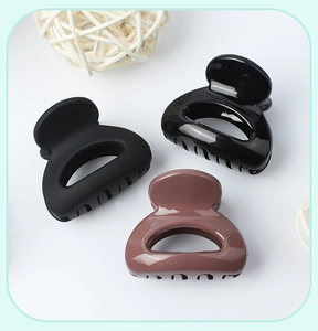 Close-up of matte and glossy mini hair claws in black and brown on a white background