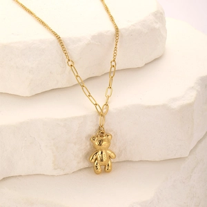 Detail of golden 3D bear pendant with textured surface and stylish link chain necklace
