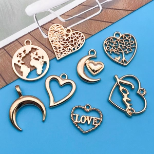 Detailed flat lay of golden hollow heart and moon pendants for DIY jewelry making