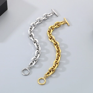 Detail of chunky gold and silver Cuban chain bracelets with toggle clasp design