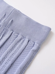 Detailed close-up of purple knit polo set showing elastic waistband and hollow out pattern