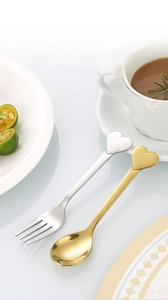 Macro view of heart-shaped stainless steel gold spoon and silver fork set