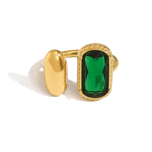 Vue macro d'une bague dorée vintage avec pierre émeraude et pièce métallique ovale