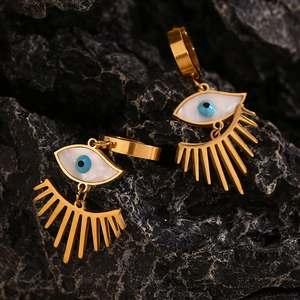Gros plan détaillé de boucles d'oreilles œil porte-bonheur en plaqué or 18 carats sur pierre