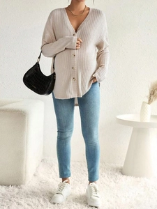 Close-up of beige ribbed knit maternity cardigan with button front and V-neckline