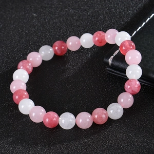 Close-up of bohemian yoga bracelet with pink, strawberry, and white crystal beads on black