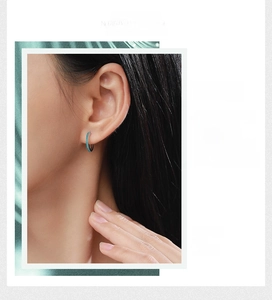 Detail of 925 sterling silver hoop earrings with turquoise pave setting on model ear