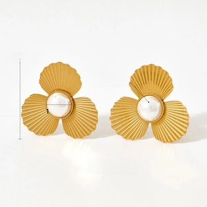 Detail of vintage gold flower earrings with ribbed petals and central pearl inlay