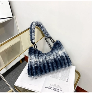 Detailed close-up of blue-gray gradient faux fur texture and twisted handle on fashion handbag