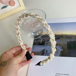 Close-up of cream white faux pearl beaded headband with twisted fabric detail