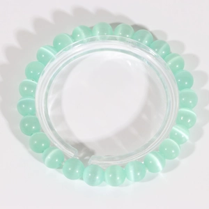 Fashionable mint green cat eye stone beaded bracelet with silk luster on white background