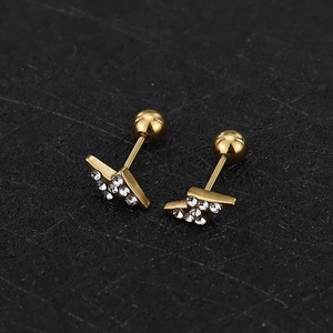 Macro detail of golden lightning bolt earring with sparkling cubic zirconia inlay and screw back