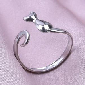 Detailed macro shot of a silver cat-shaped adjustable stainless steel ring on pink satin
