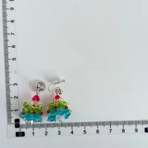 Beaded Christmas tree earring with red bow detail shown on scale measurement board