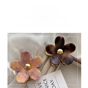 Detailed macro of acetate flower hair claw with elegant tortoiseshell and marble texture