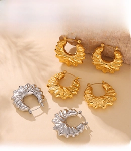 Close-up of geometric hollow flower earrings with PVD electroplated gold texture