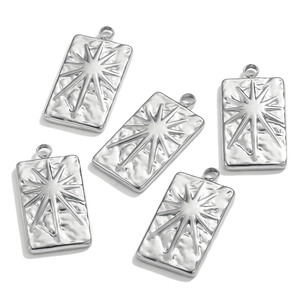 Macro detail of five silver square tarot pendants with sunburst and hammered textures