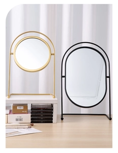 Detail of round and oval tabletop makeup mirrors in gold and black iron frames
