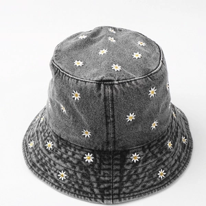 Close-up of small daisy flower embroidery on washed gray denim fisherman bucket hat