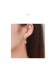 Detail of S925 silver dangle earring featuring a colorful round zircon on model