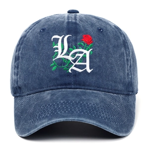 Detail view of gothic LA embroidery with red rose and green thorns on blue cotton cap