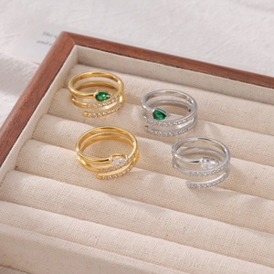 Set of layered snake rings with pear-cut green and white crystals in gold and silver finish