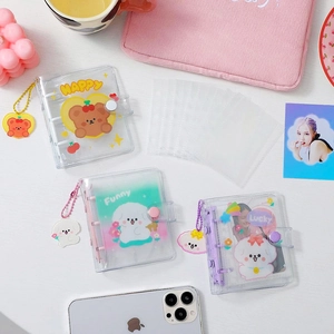 Three mini PVC binders with cute cartoon animals and matching acrylic pendants on a desk