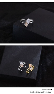 Detail of interlocking two-tone pear-cut cubic zirconia rings in gold and silver finishes